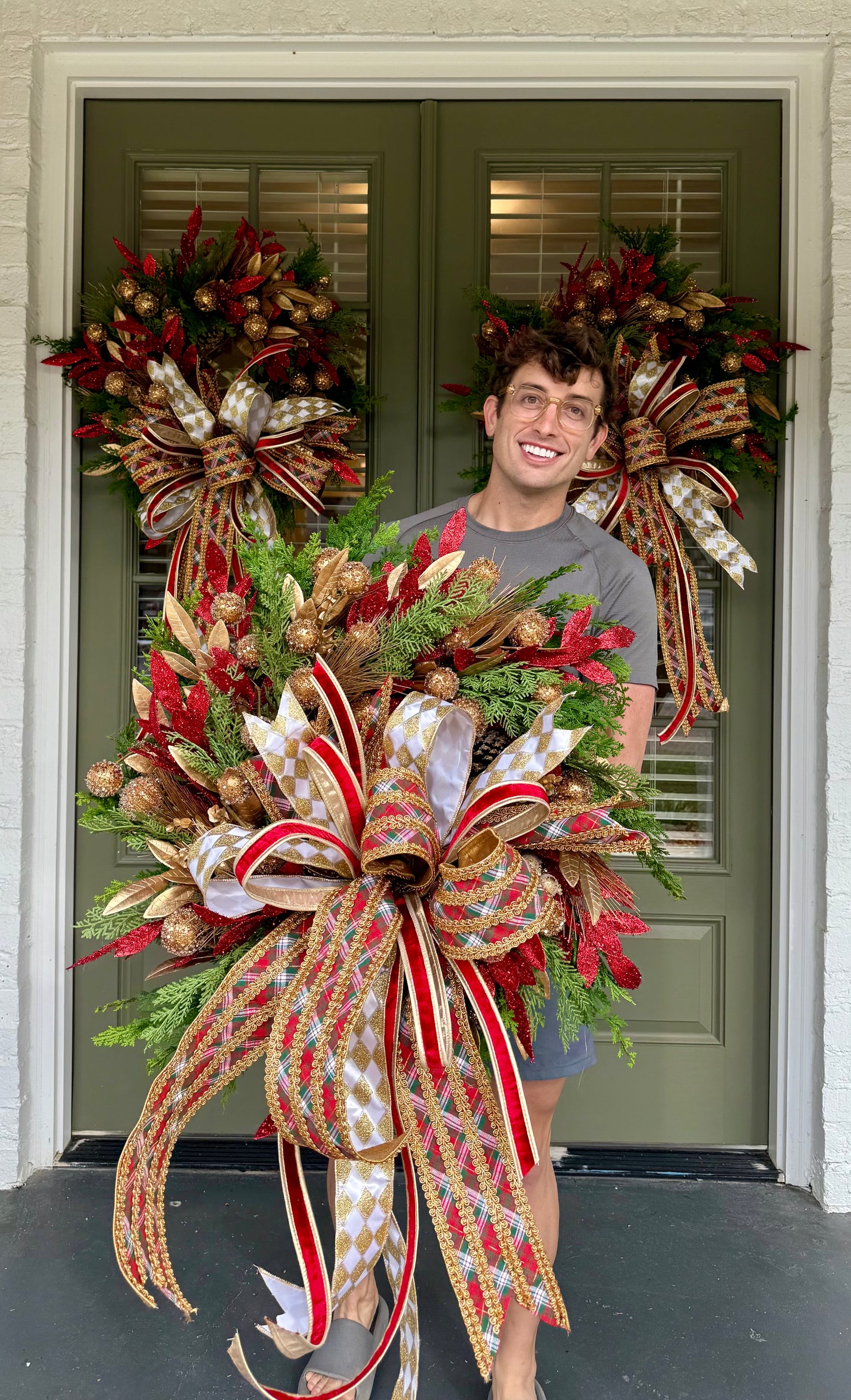 Red green gold faux wreath. Very full hand made wreath by JME and tied with a JME bow. About 30 inches wide
