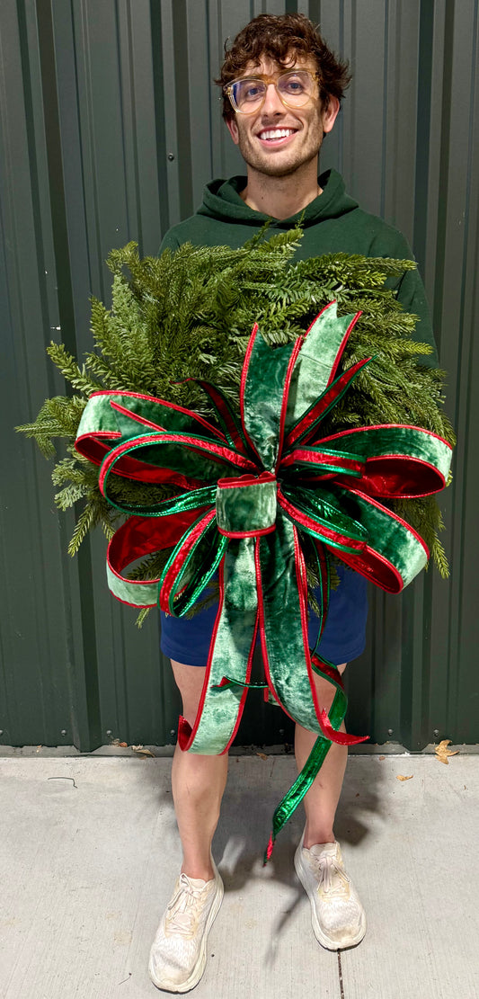 Faux mix winter foliage wreath with a hand tied JME green velvet bow. About 24 inches in diameter.