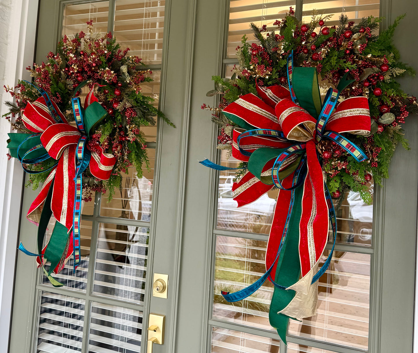 Red jingle bell JME handmade wreath with a JM nutcracker inspired bow. About 24 inches wide.