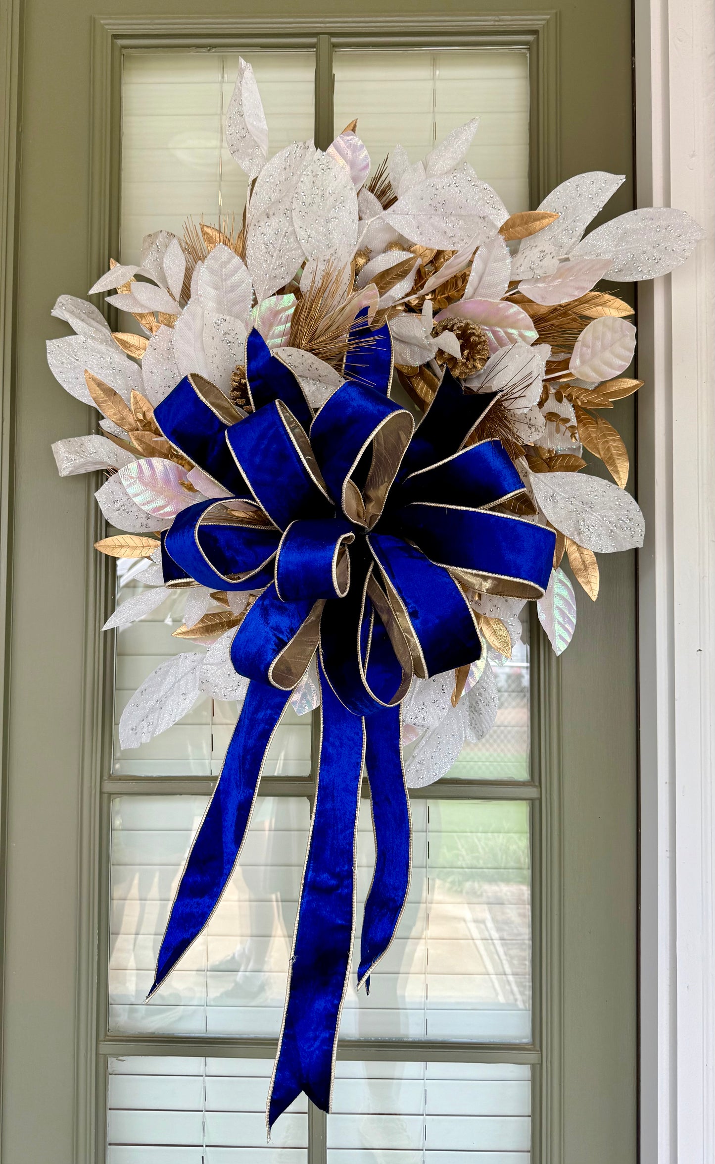 Gold and white wreath with hand tied JME navy velvet bow with gold backing.