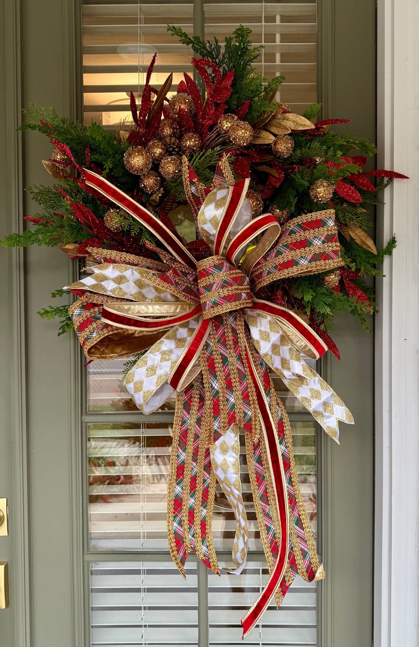 Red green gold faux wreath. Very full hand made wreath by JME and tied with a JME bow. About 30 inches wide