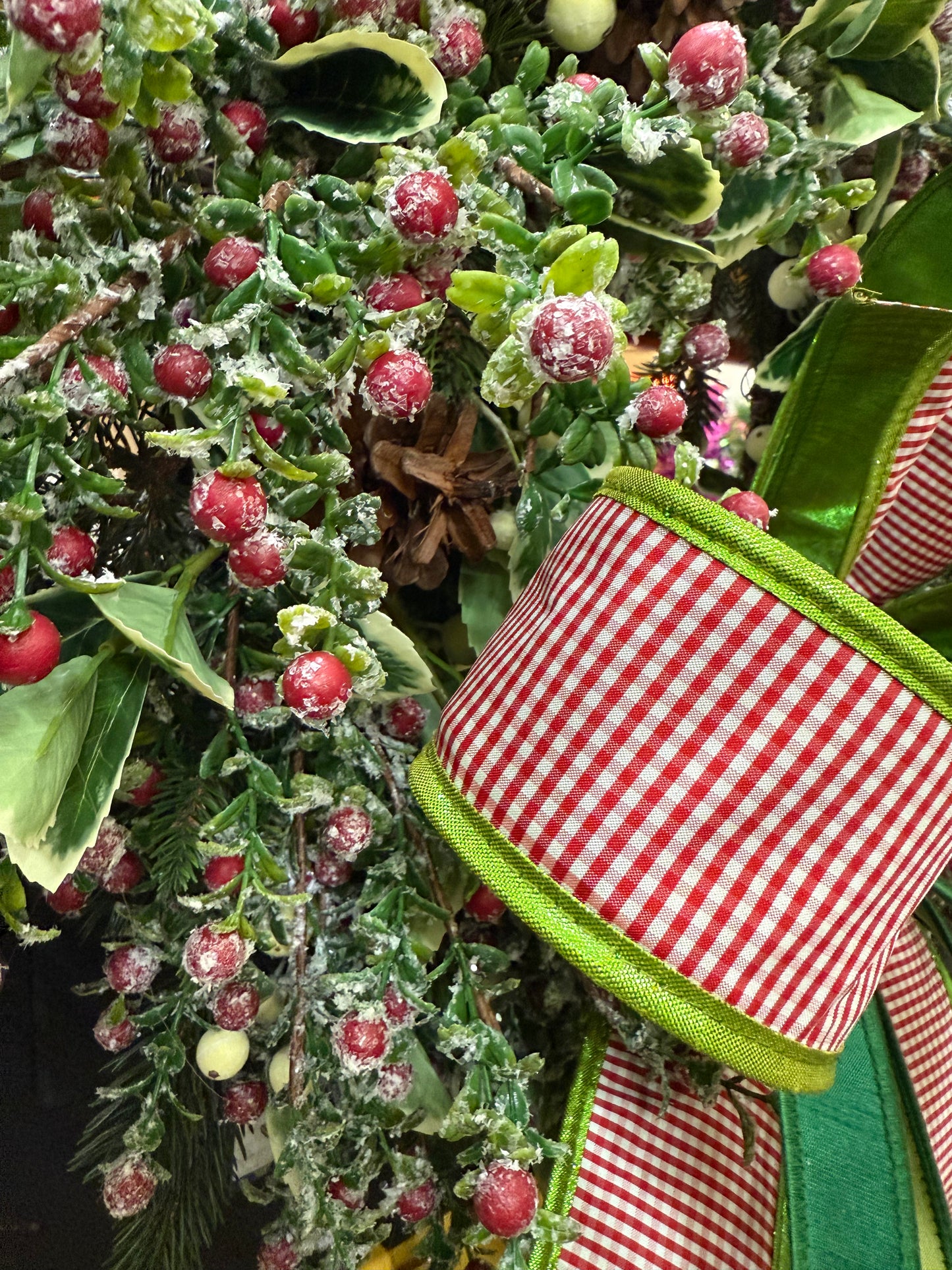 Faux Red snow berry and mixed foliage wreath. Handmade by JME paired with a JME handtied bow. About 24 inches wide.