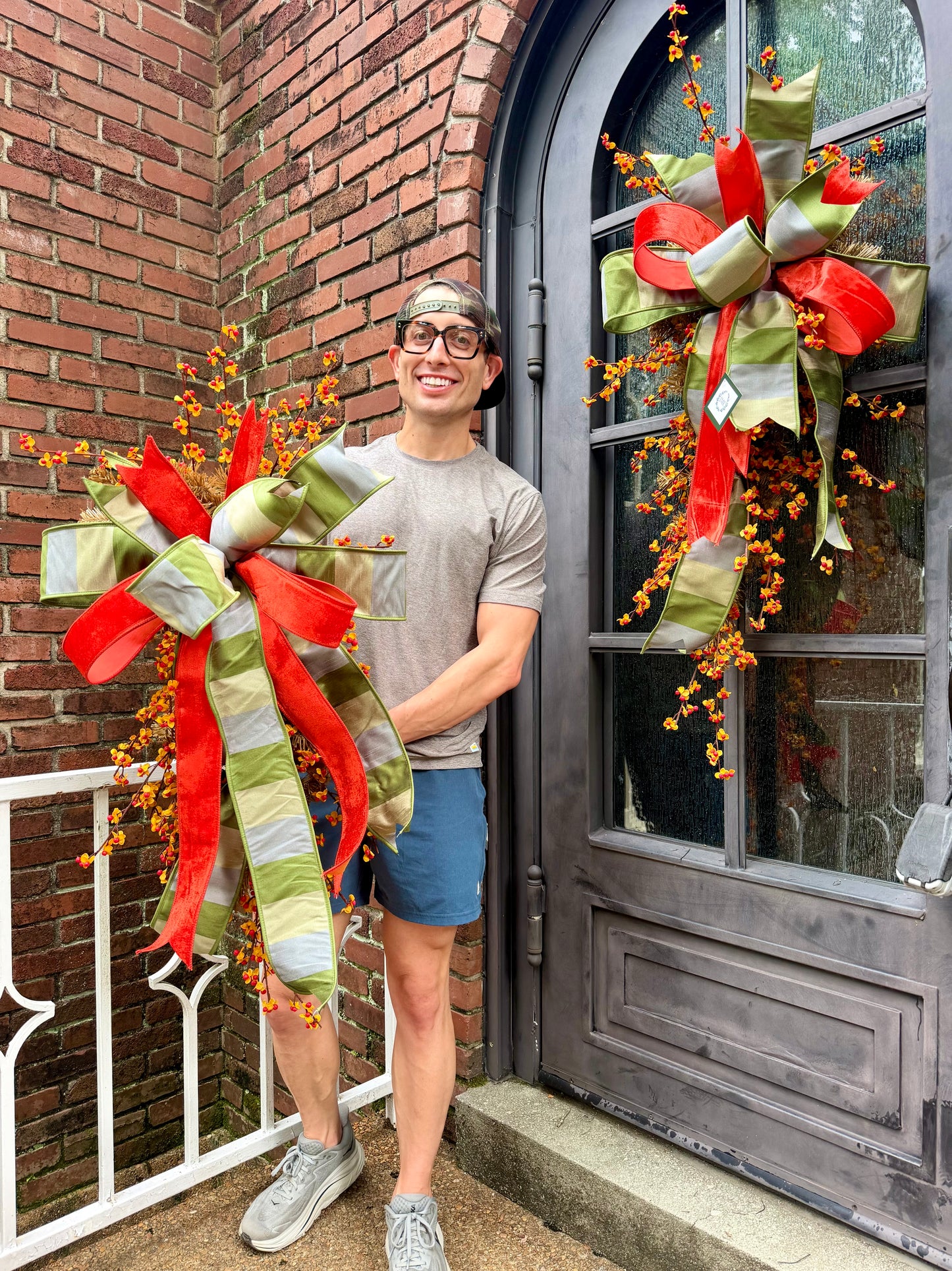 Handmade JME fall door swag made with bittersweet. Paired with a beautiful green grey tan and orange velvet JME bow. About 3 feet long by 21 inches wide. *Some fluffing may be required upon receiving.