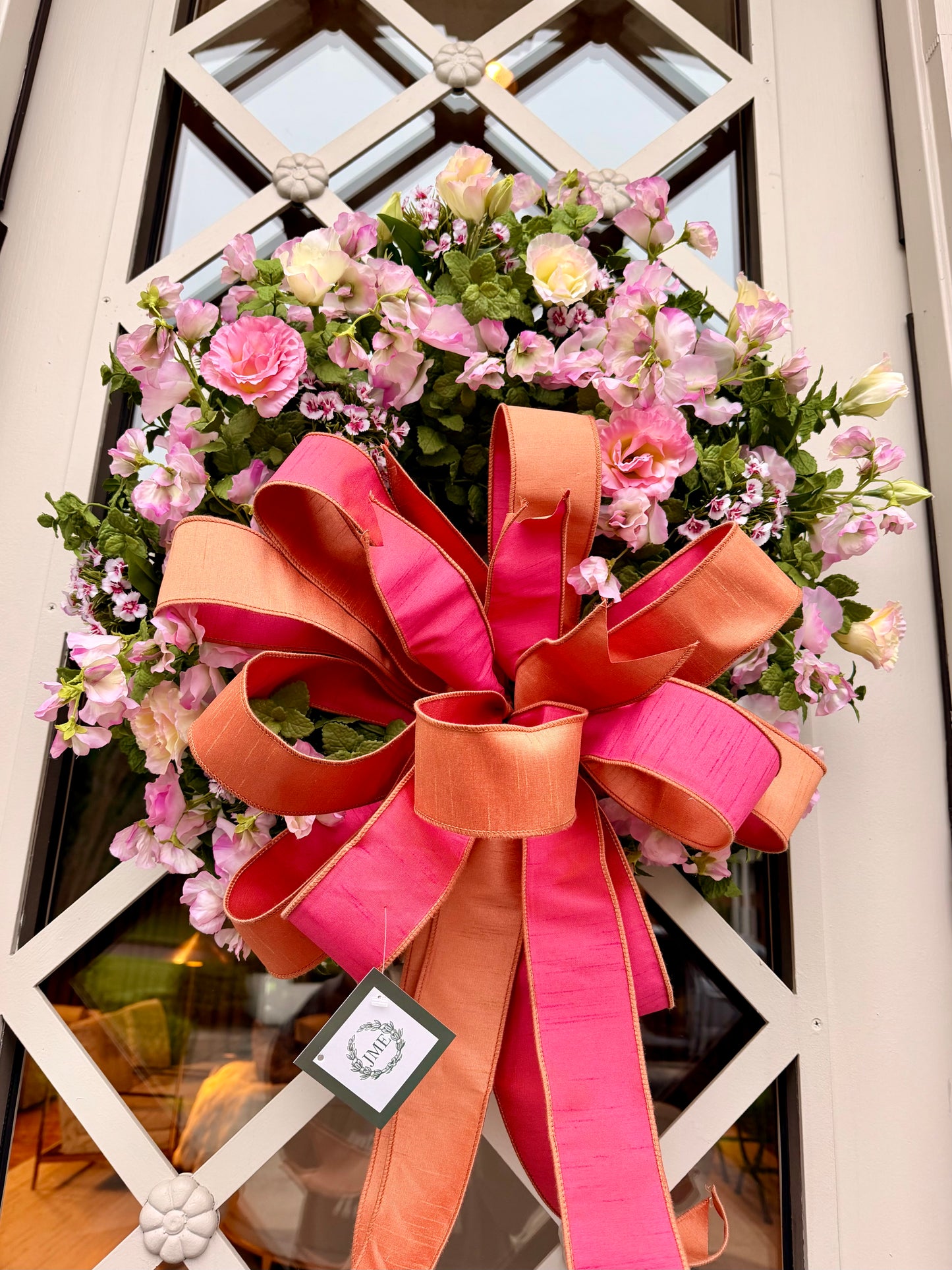JME hand made wreath. Faux blush and soft pink florals mixed with greenery tied with a JME hand tied coral inspired bow. About 24inches in diameter.