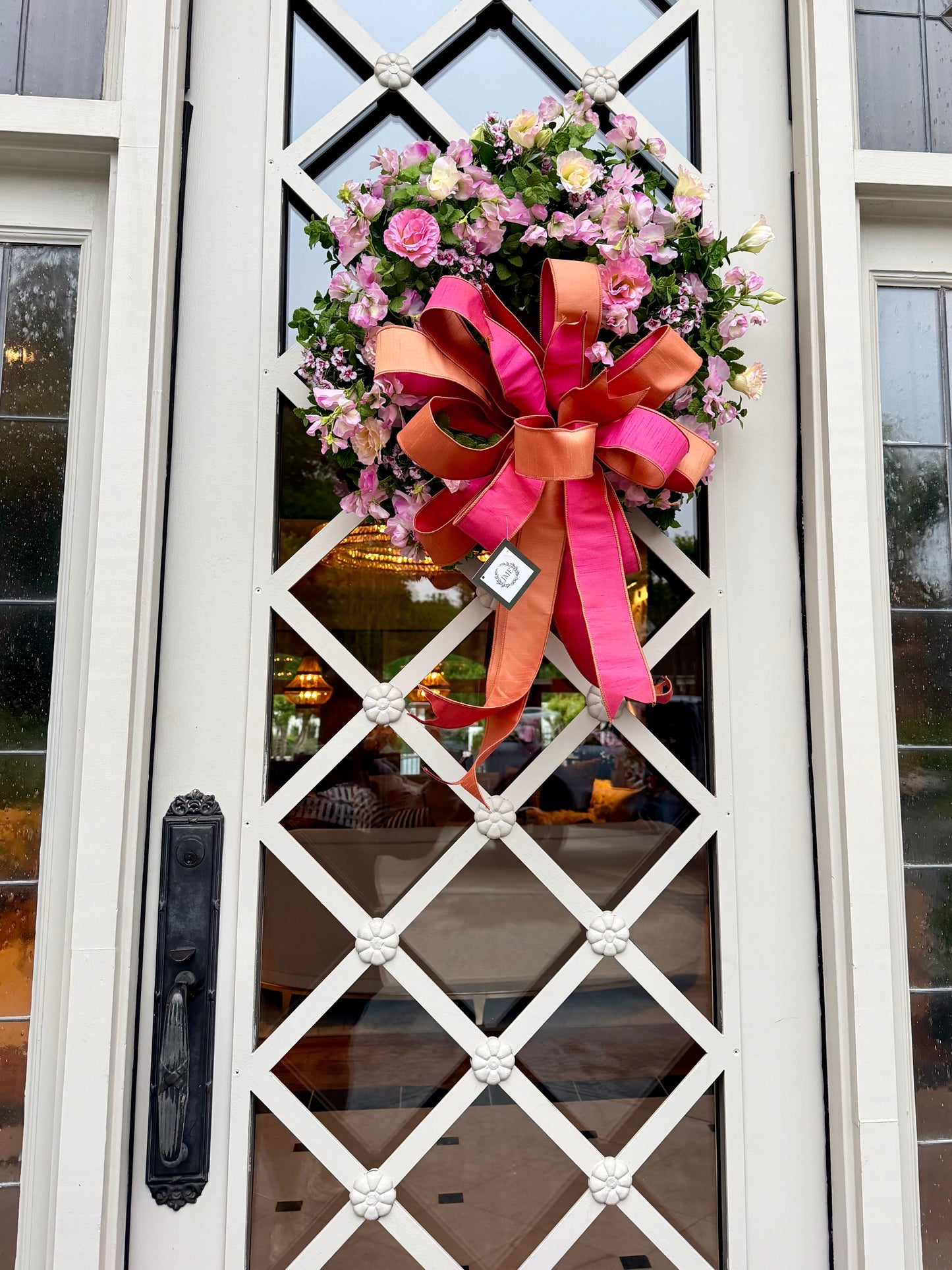 JME hand made wreath. Faux blush and soft pink florals mixed with greenery tied with a JME hand tied coral inspired bow. About 24inches in diameter.