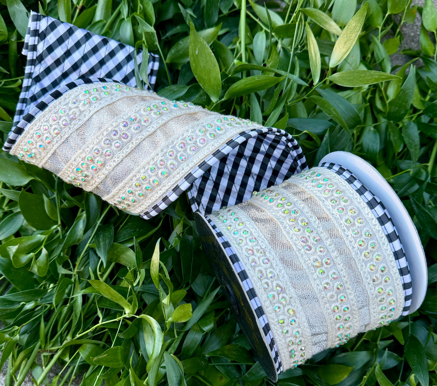 JME heavy wired ribbon. Metallic ribbon with jewel, cream, bands, and black and white piping. Backed with black and white diagonal checked. 4” x 5 yards.