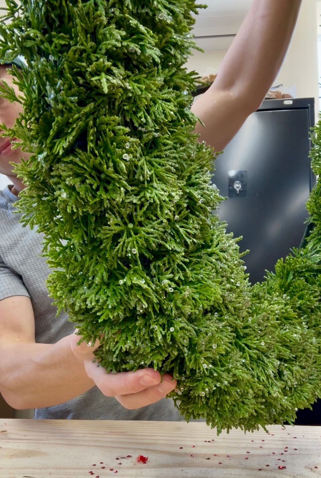 Oval frosted faux cedar wreath. 23inches wide by 30.5 inches long