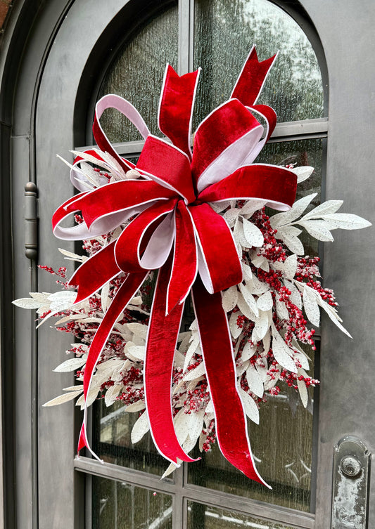 Handmade JME wreath. White icy bay leaves, and icy berries. with a hand tied JME red velvet bow. About 24 inches wide.