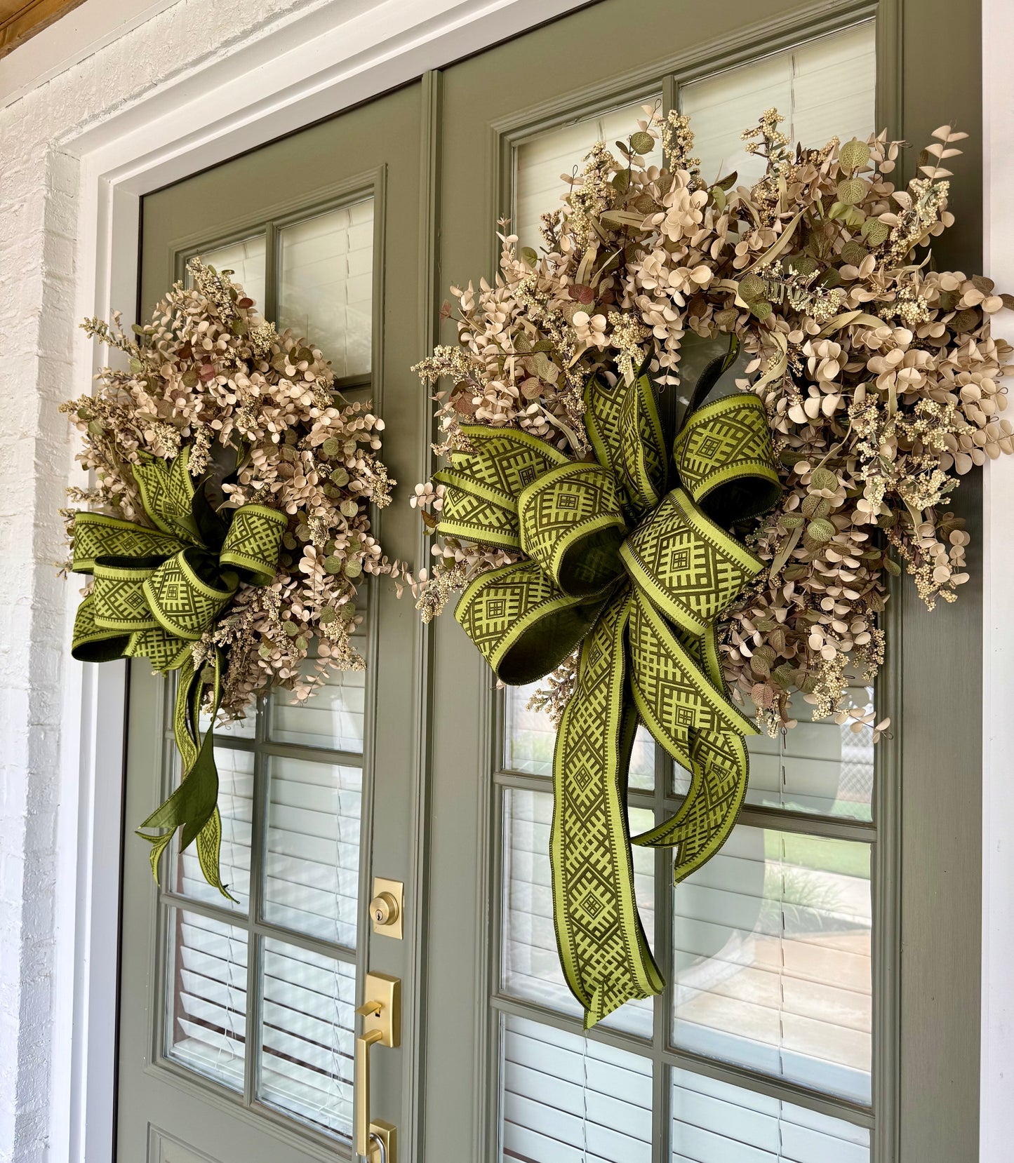 Faux cream eucalyptus and mixed foliage wreath with a hand tied green JME bow.