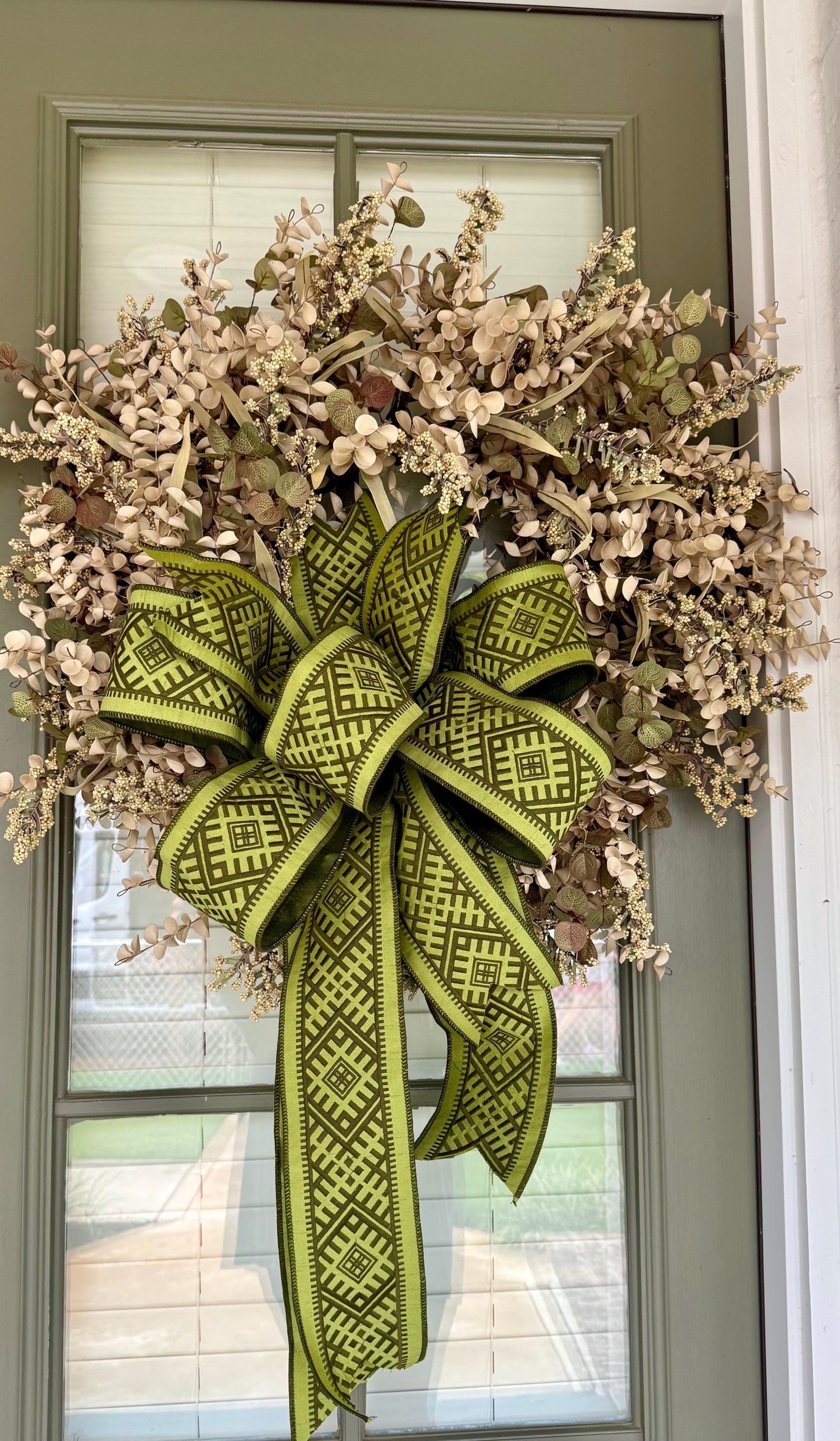 Faux cream eucalyptus and mixed foliage wreath with a hand tied green JME bow.