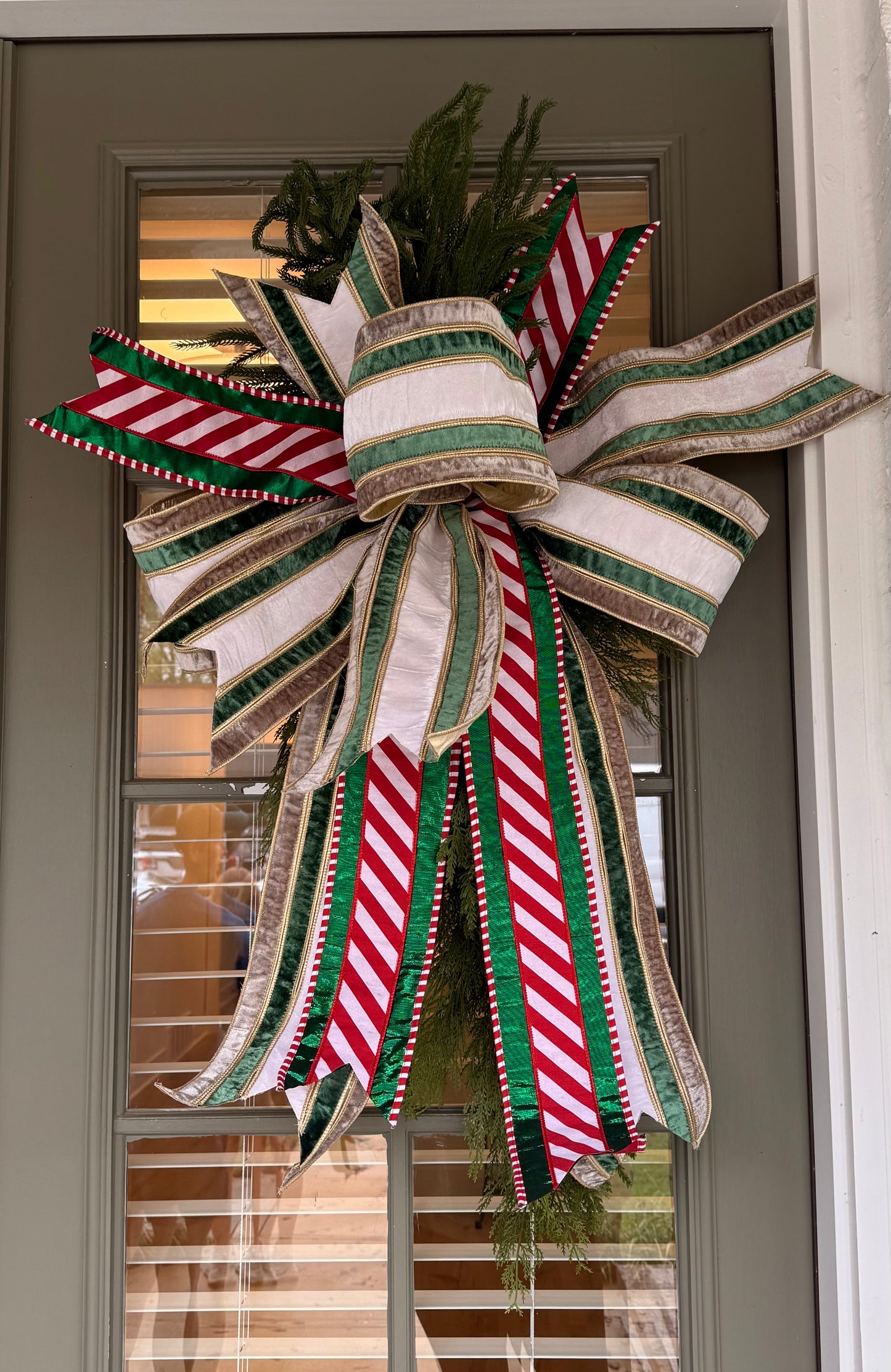 Cedar swag with a JME hand-tied bow using 6in velvet ribbon paired with a pattered ribbon. About 42 inches long