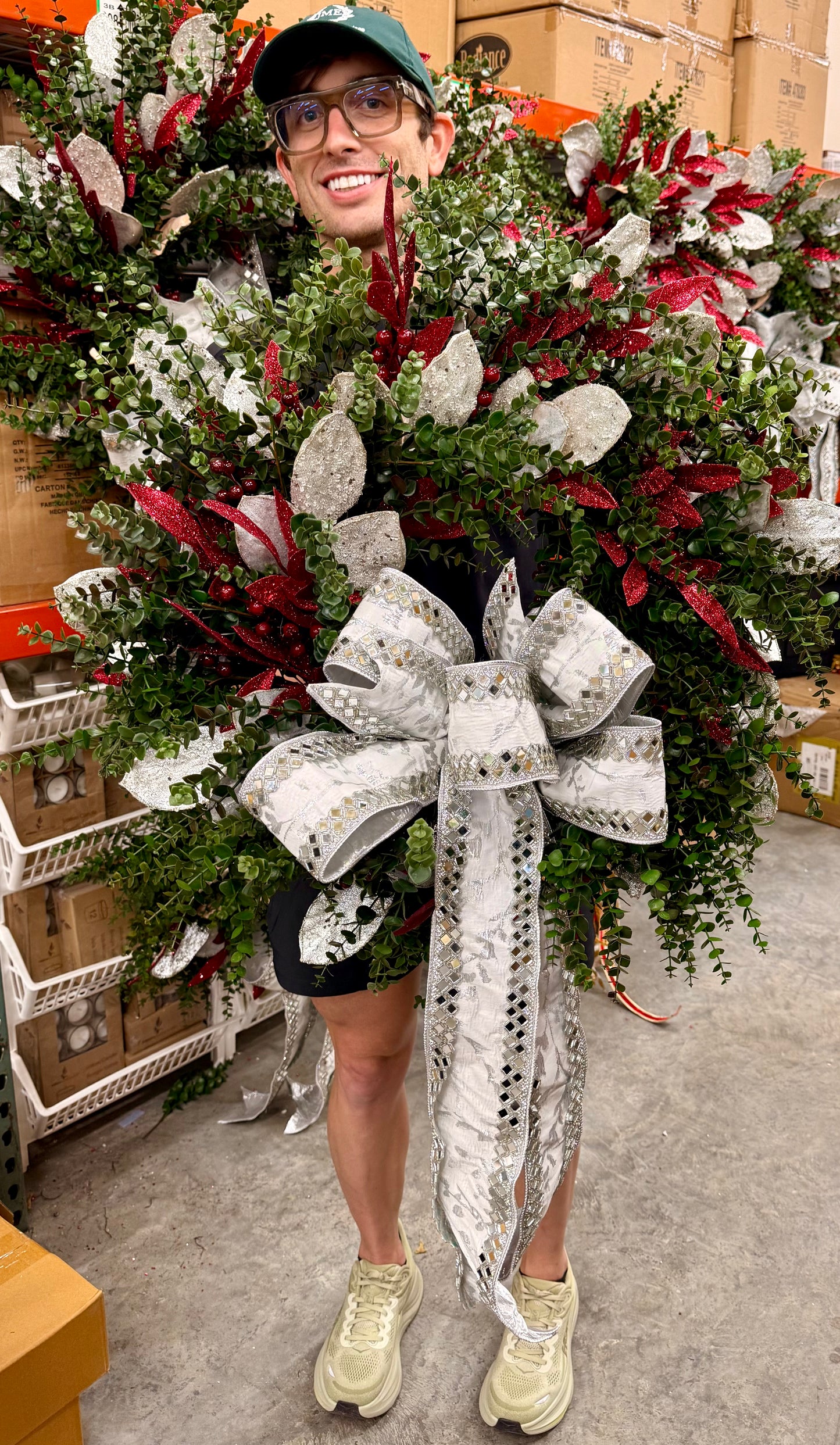 Faux Boxwood JME wreath with burgundy and silver touches. Paired with a JME white and mirrored bow. About 24 inches wide.