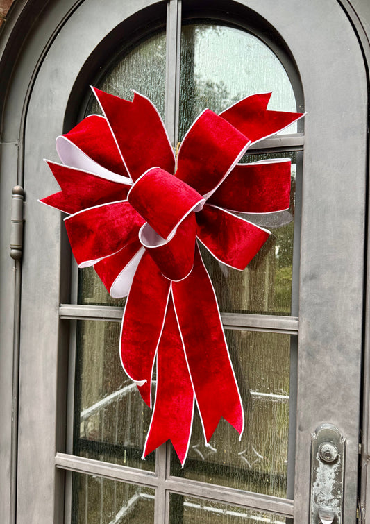 JME hand tied though about 20 inches wide. Made with JME red velvet ribbon with white backing. Some fluffing may be required upon receiving.