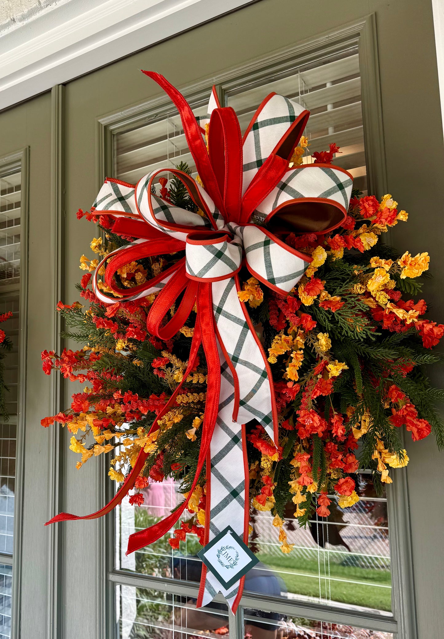 Handmade JME WREATH made of mixed foliage and paper flowers. With a JME orange velvet and green plaid bow. About 24in wide.SHIPPING MONDAY AUGUST 18th