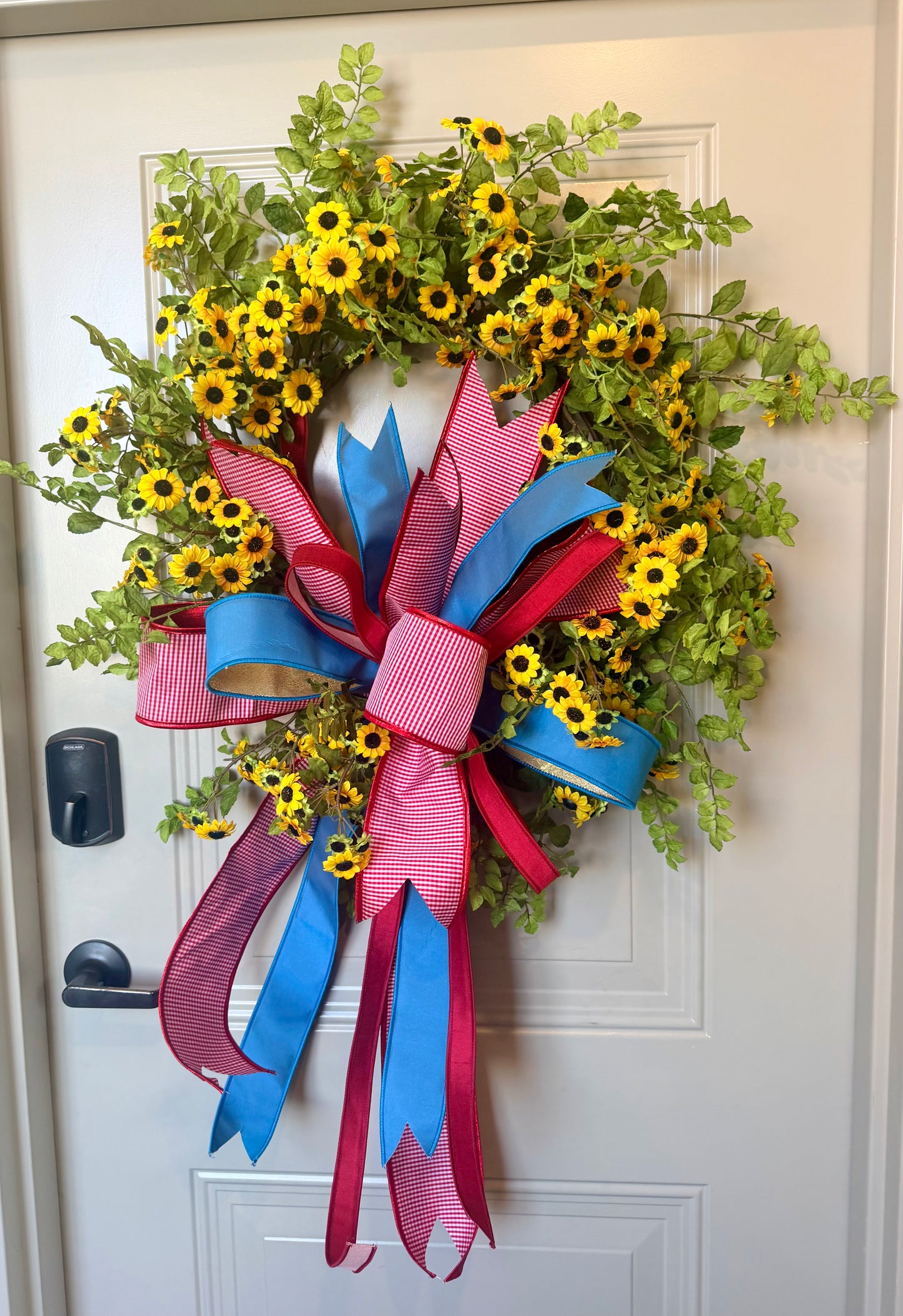 JME mini sunflower wreath WITH a JME hand tied patriotic bow. About 27 inches in diameter.