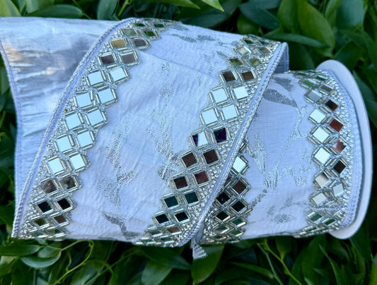 JME Heavy wired ribbon. White/silver leaf vine ribbon with mirrored diamond trim work. Back with silver metallic. 4“ x 5 yards.