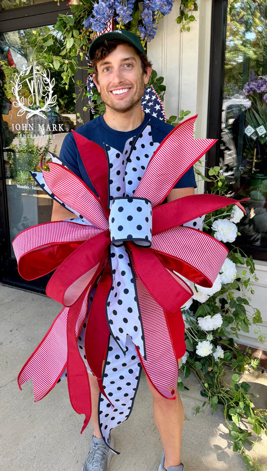 JME white  with navy polka dots bow. Hand-tied by JME. Approximately 23inches wide and inches 32inches long.